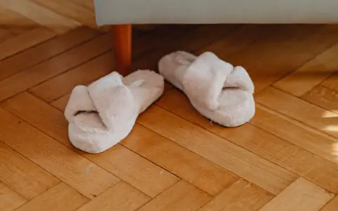 Representative photo: Pair of fuzzy slippers on a wooden floor. Not the exact product; the deal link goes to the actual product.